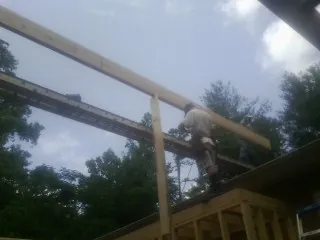 Carpenter setting a ridge beam over a new addition frame — Ice Dam Removal by Roofing Brothers in Mountain Top