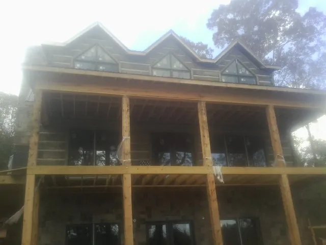 Dormers and porch framing on a large log home under construction — Roof Coating work by our crew in Mountain Top