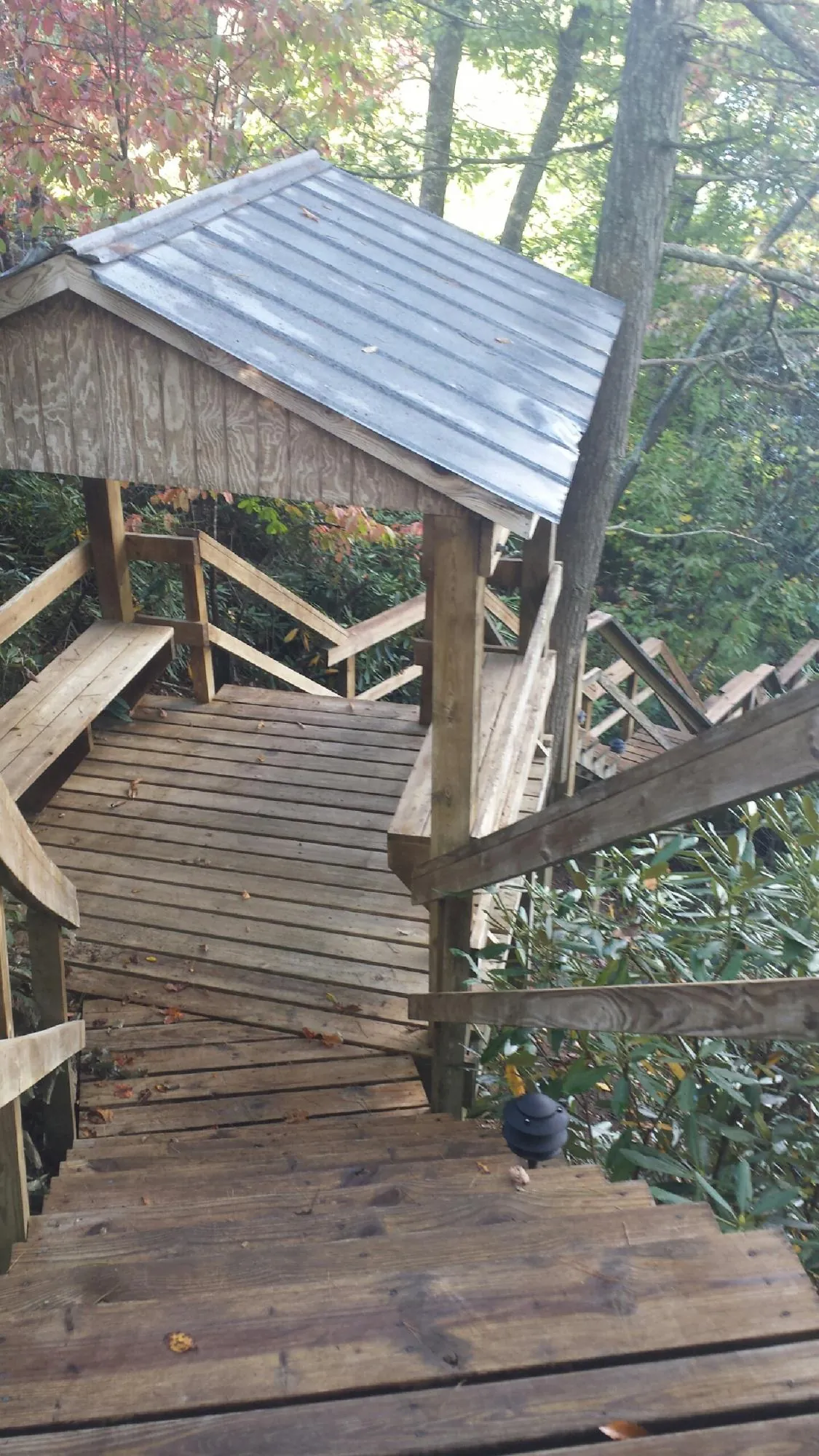 Metal roofed shelter over wooden steps on a wooded walkway — Skylight Repair & Installation work by our crew in Mountain Top