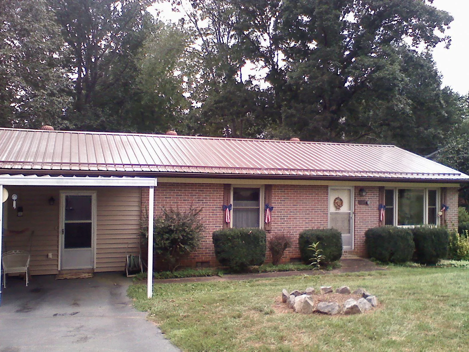 Bronze metal roof and carport on a brick ranch home — Roof Repair work by our crew in Mountain Top